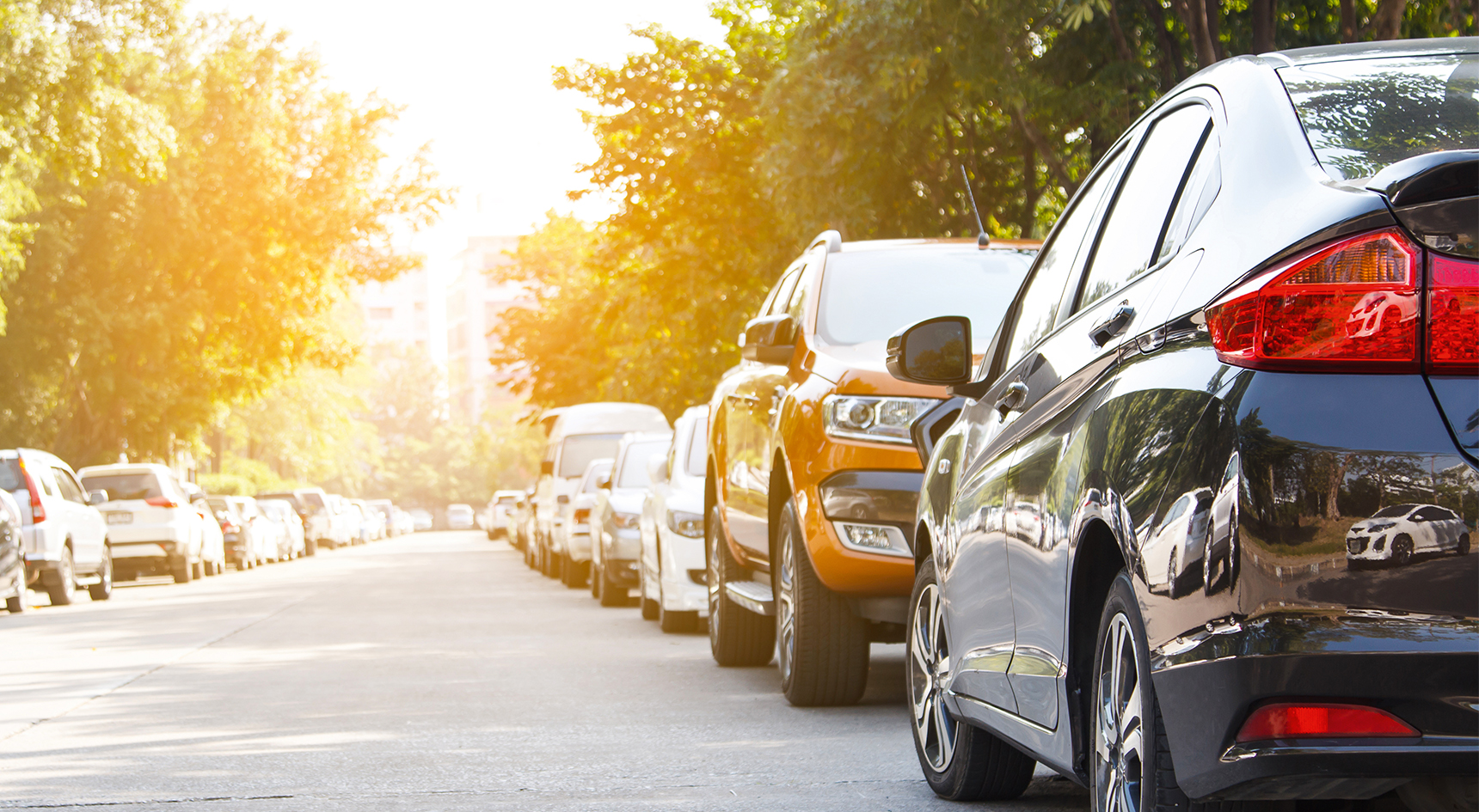 Image showing cars parked along a road - black car facing wrong way