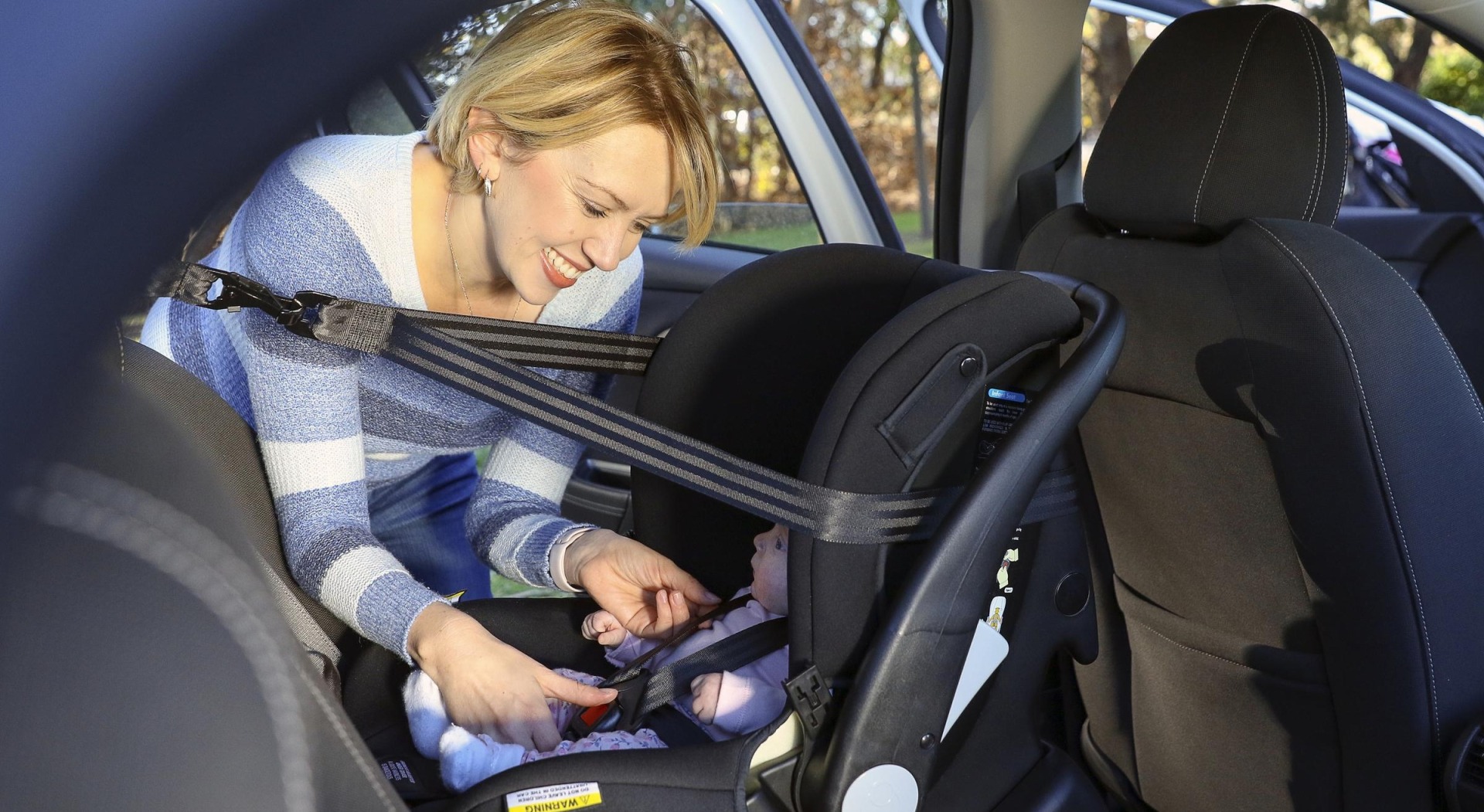 Mother placing baby into restraint