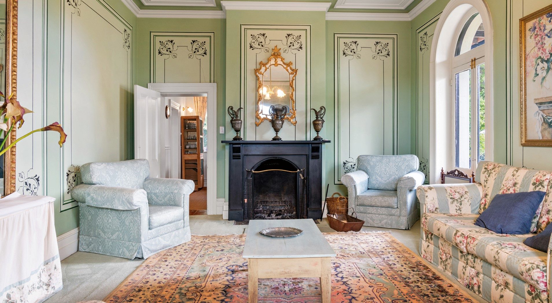 Bright lounge room with floral couches.