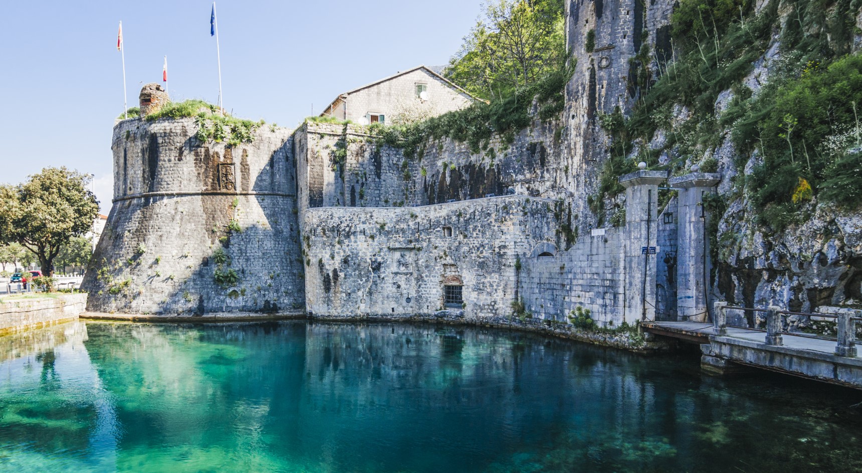 Walled city of Kotor rising from a turquoise moat