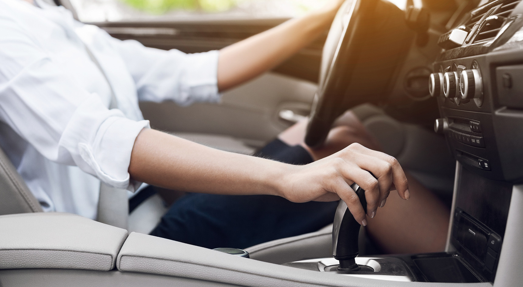 Woman driver shifting automatic transmission and driving 