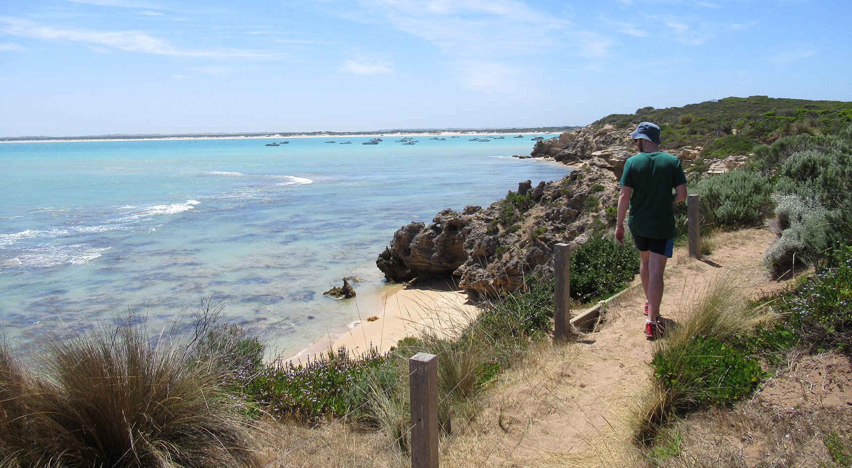 Man walking on a dirt path near the ocean