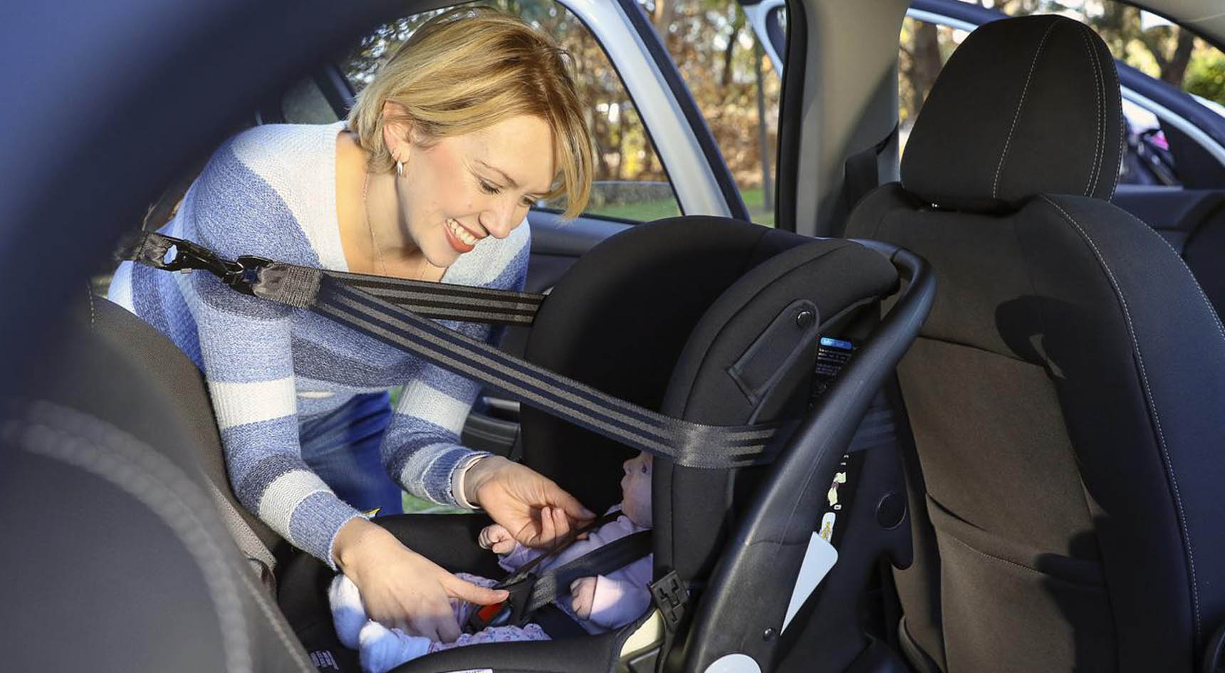 A mother checking her child's car restaint.