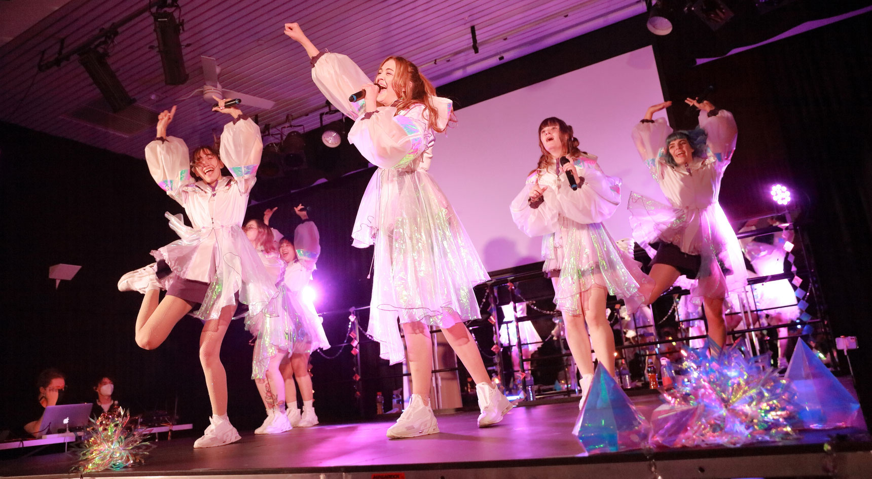 A number of dancers and singers on a stage