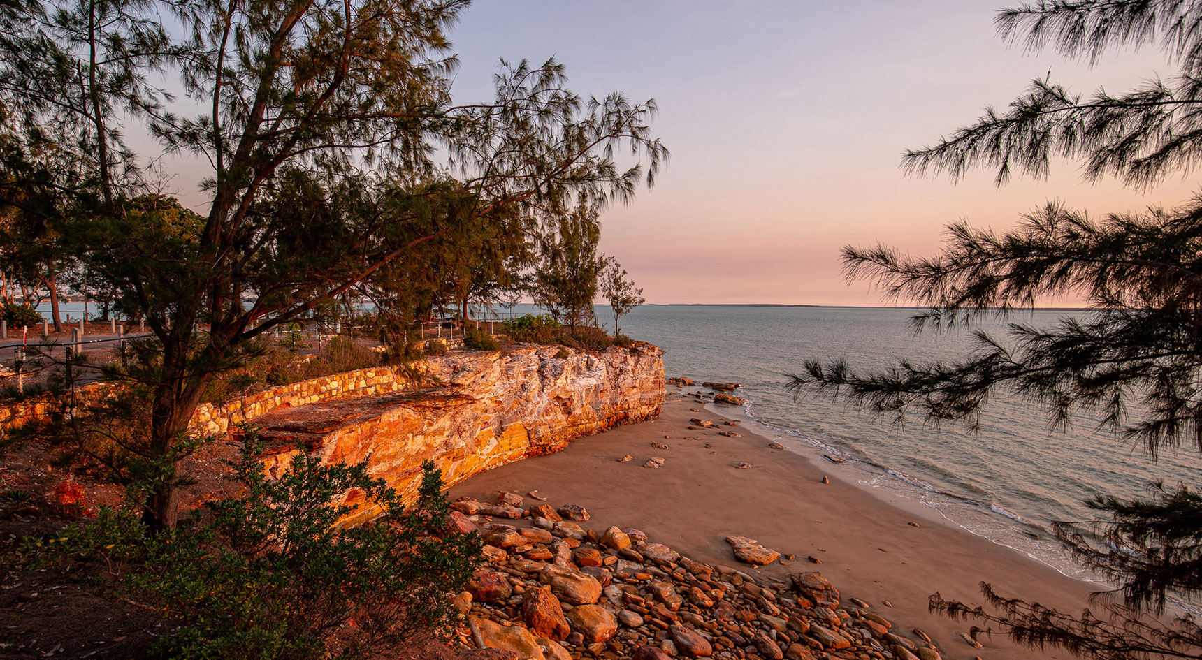 Image of a brick wall and trees at sunset