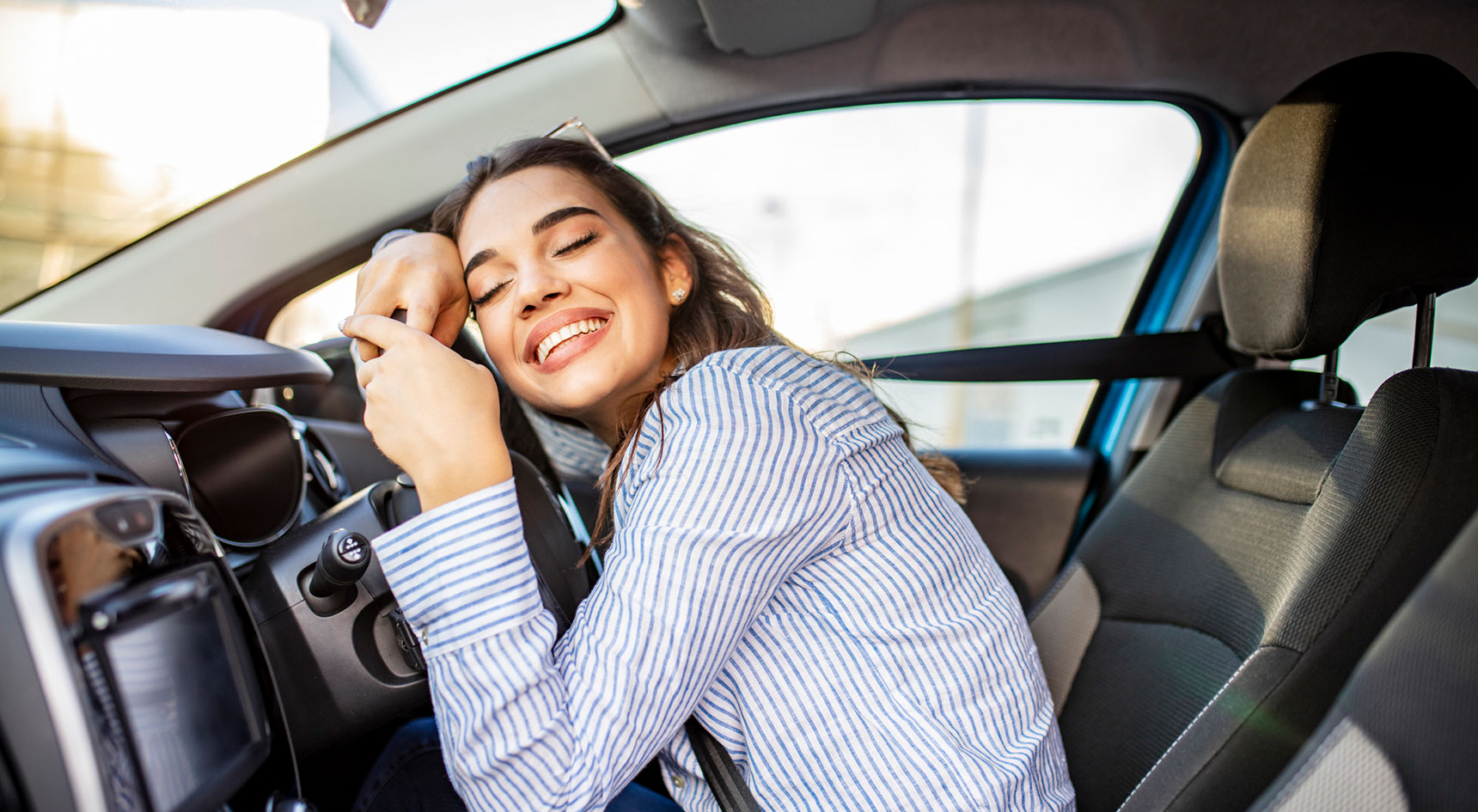 Woman hugging her car steering whele