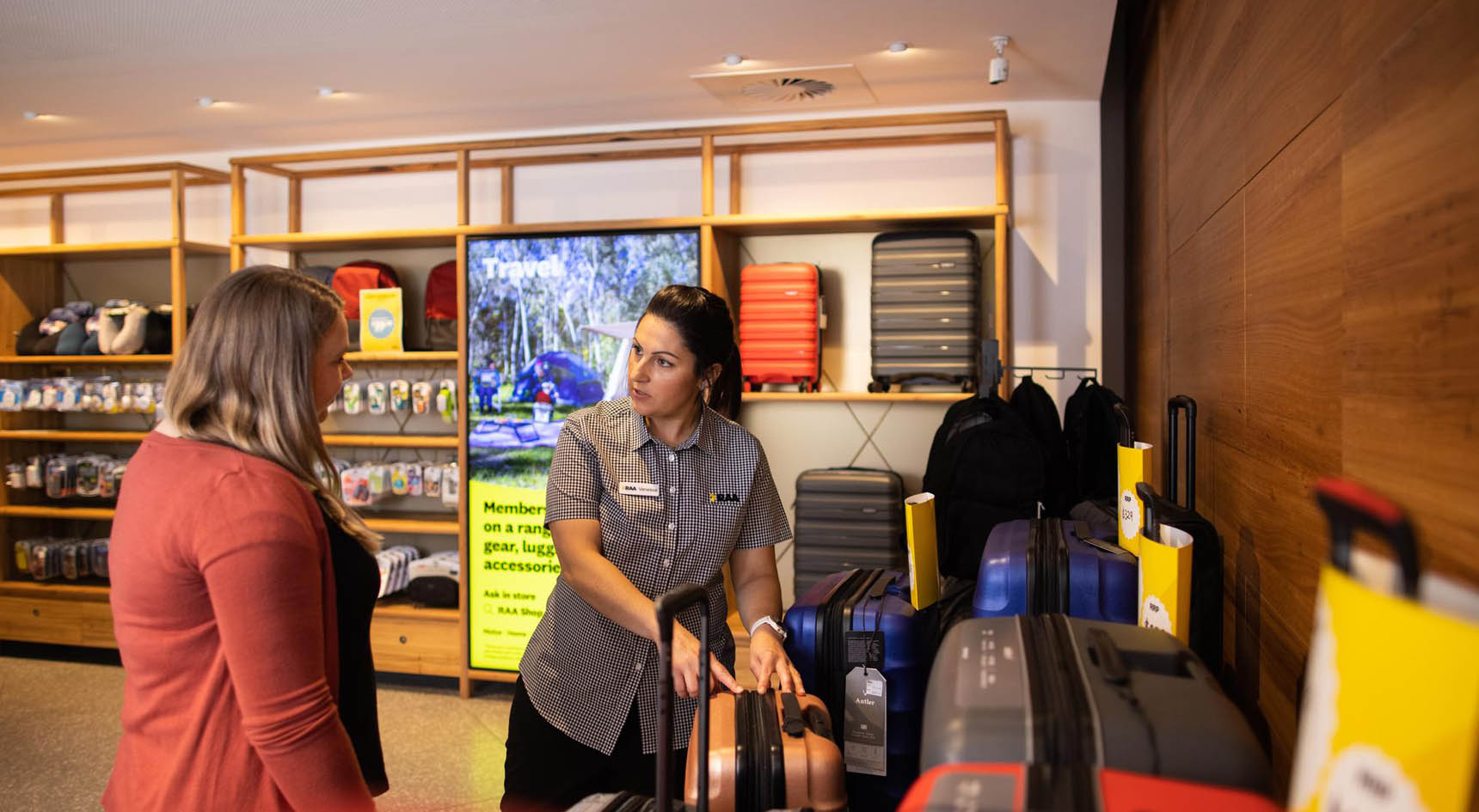 A person purchasing luggage from an RAA Shop.