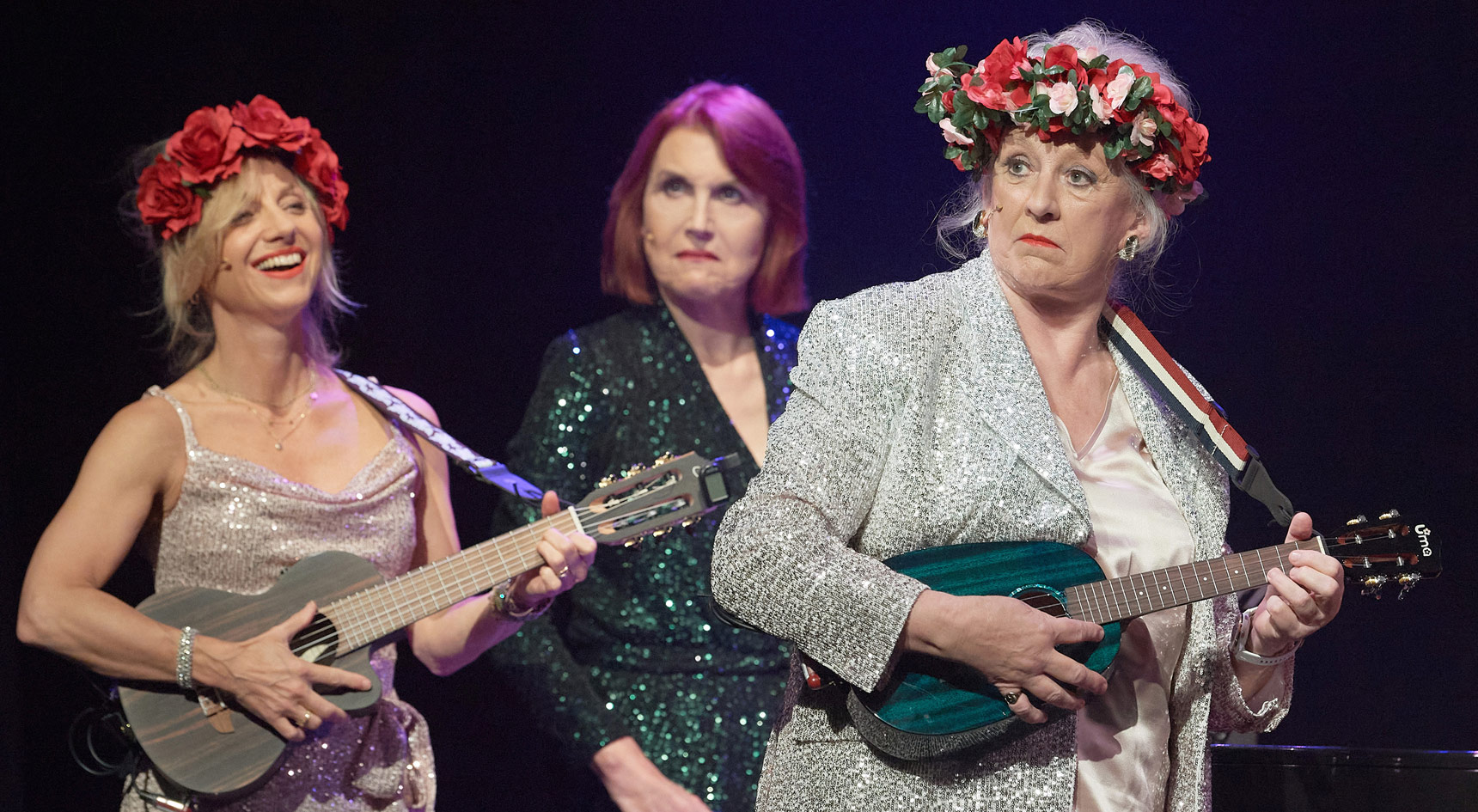 Fascinating AIDA trio performing on stage with small guitars